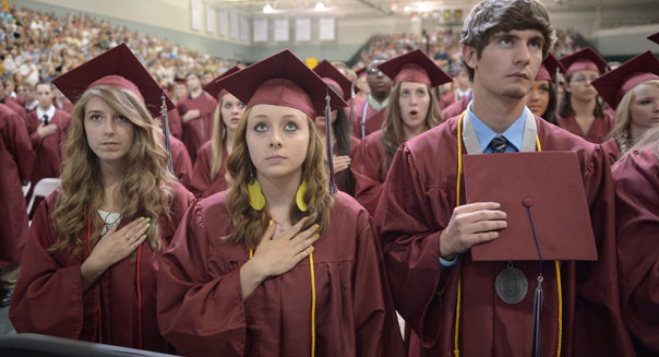 Students  listen to then national anthem prior to US President Barack Obama's  delivering of the commencement address on May 21, 2012 at Missouri Southern State University in Joplin, Missouri. AFP PHOTO/Mandel NGAN        (Photo credit should read MANDEL NGAN/AFP/GettyImages)