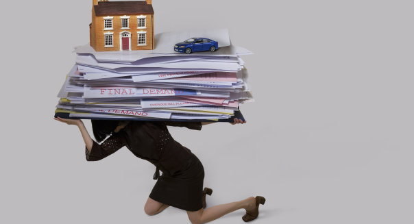 woman carrying a stack of bills, house and a car